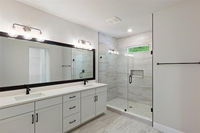 full bath with a sink, double vanity, and a shower stall