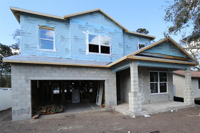 property under construction with concrete block siding and a garage