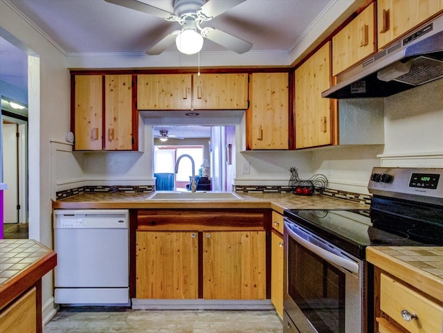 kitchen with tile countertops, white dishwasher, under cabinet range hood, a sink, and stainless steel range with electric cooktop