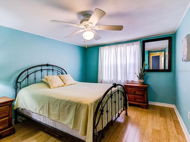 bedroom featuring ceiling fan, wood finished floors, and baseboards