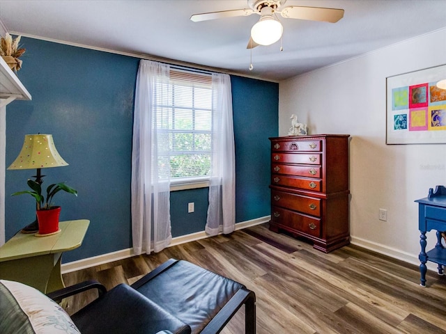 sitting room featuring crown molding, ceiling fan, wood finished floors, and baseboards