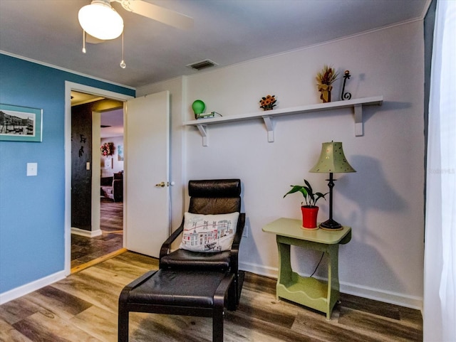 sitting room featuring a ceiling fan, baseboards, visible vents, and wood finished floors