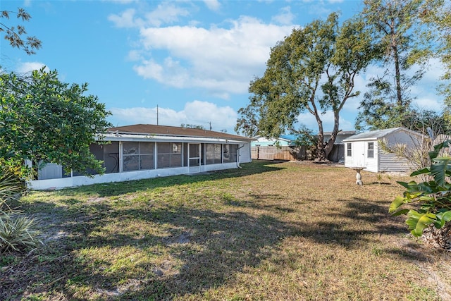 view of yard with a sunroom and an outbuilding