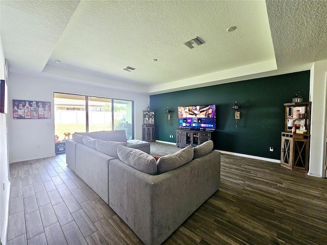 living room with a tray ceiling and a textured ceiling