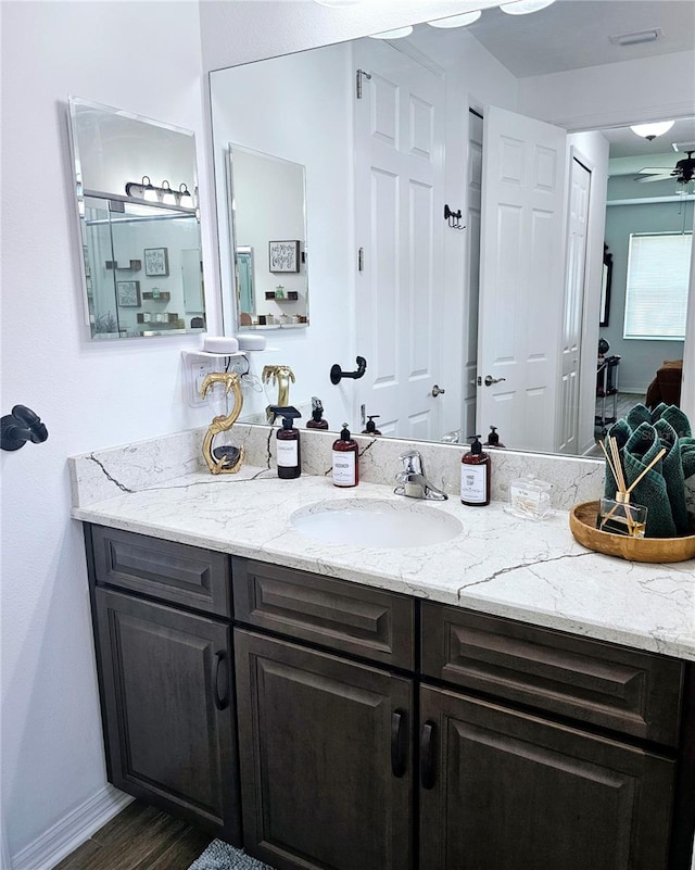 bathroom with ceiling fan, vanity, and hardwood / wood-style floors