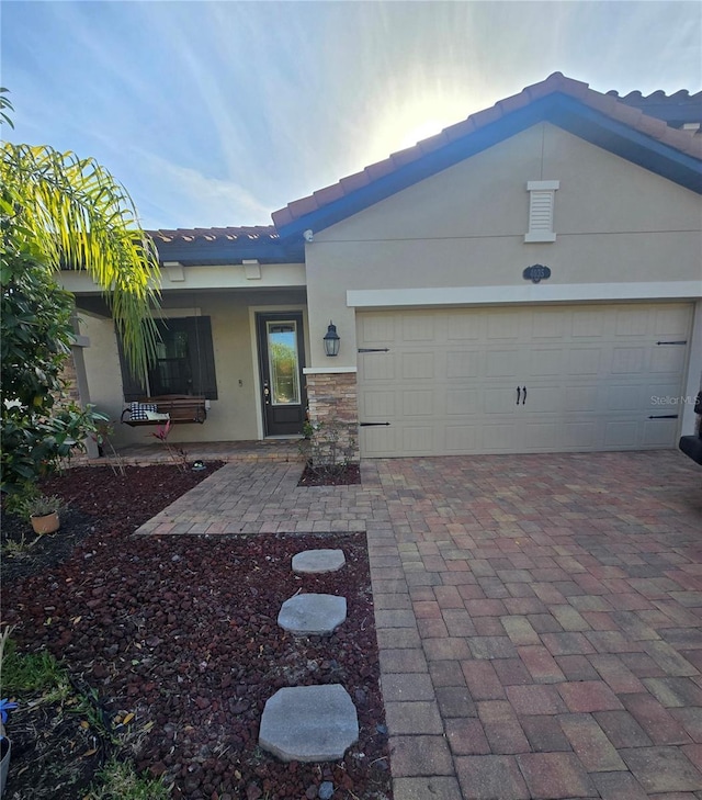 4035 Solamor St, Lakeland, FL 33810 - exterior space featuring a tiled roof, decorative driveway, stucco siding, and an attached garage