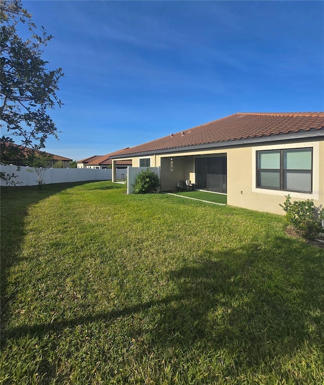 4035 Solamor St, Lakeland, FL 33810 - back of property featuring stucco siding, a tile roof, fence, and a lawn