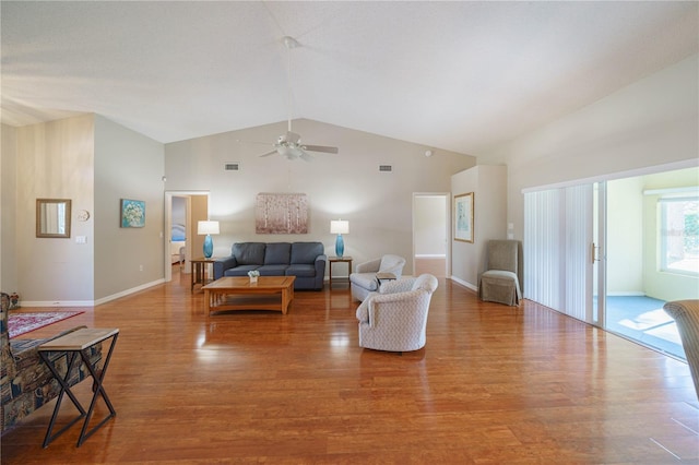 living area with high vaulted ceiling, visible vents, and wood finished floors