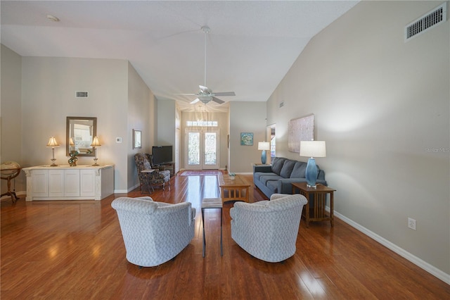 living room with high vaulted ceiling, wood finished floors, visible vents, and baseboards