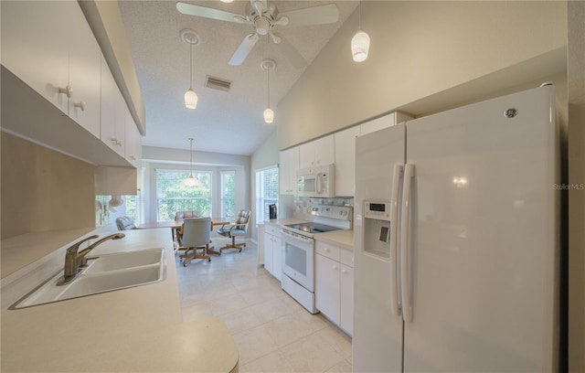 kitchen with light countertops, visible vents, white cabinetry, a sink, and white appliances