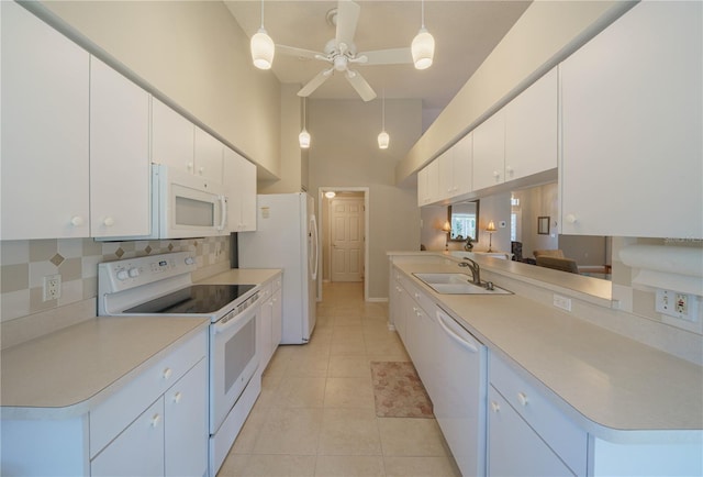 kitchen with decorative backsplash, white cabinets, a sink, light tile patterned flooring, and white appliances