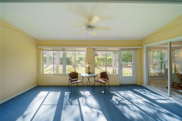 unfurnished sunroom with a ceiling fan, a wealth of natural light, and vaulted ceiling