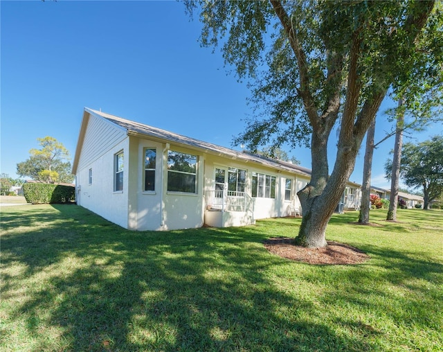 view of front facade with a front yard and stucco siding