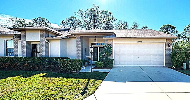 view of front of house with a garage, concrete driveway, brick siding, and a front lawn