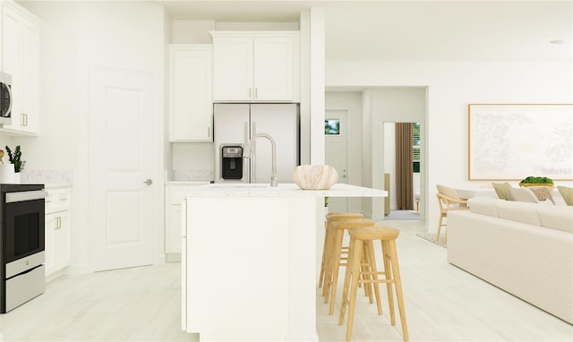 kitchen featuring a kitchen island with sink, electric stove, white fridge with ice dispenser, and white cabinets