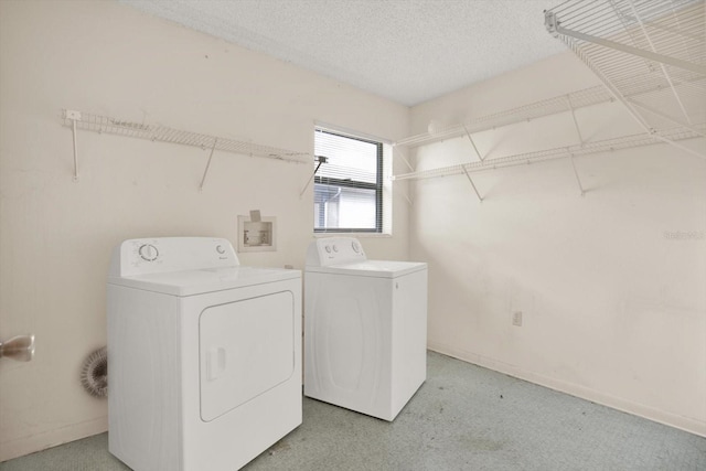 laundry room with washing machine and dryer and a textured ceiling