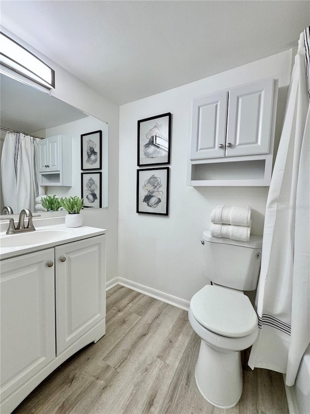 full bathroom featuring baseboards, a shower with shower curtain, toilet, wood finished floors, and vanity