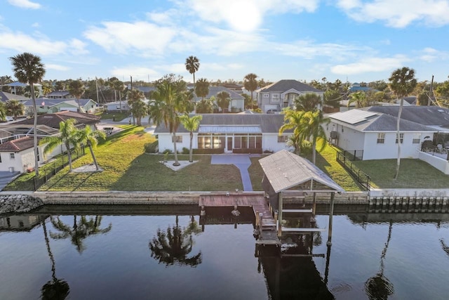 rear view of property with a lawn and a water view