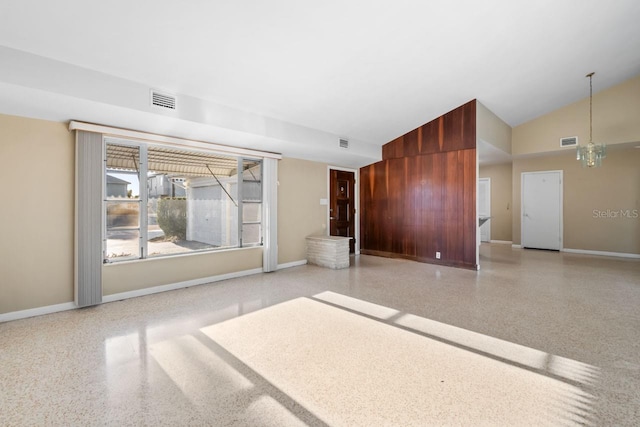 unfurnished room featuring vaulted ceiling, a chandelier, and wooden walls