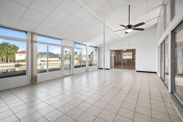 empty room featuring ceiling fan, lofted ceiling, and light tile patterned floors