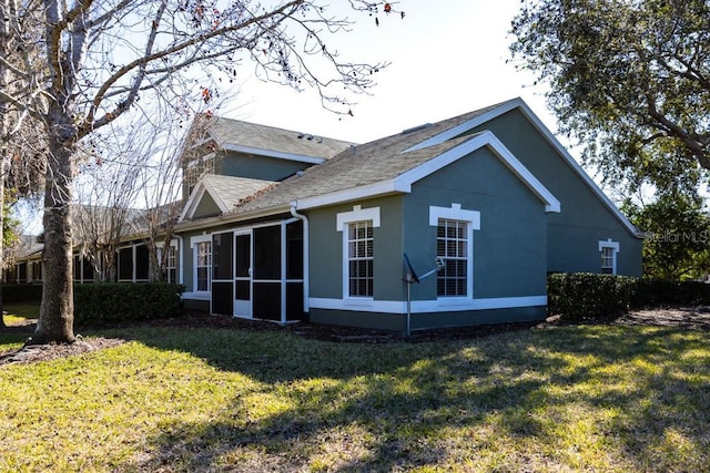 view of side of property featuring a sunroom and a lawn