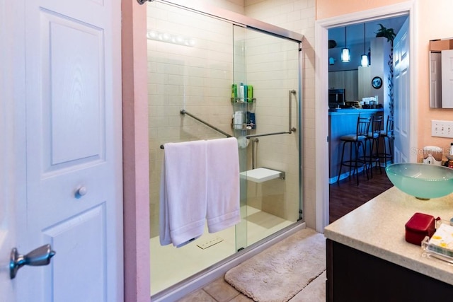 bathroom featuring vanity and a shower with door