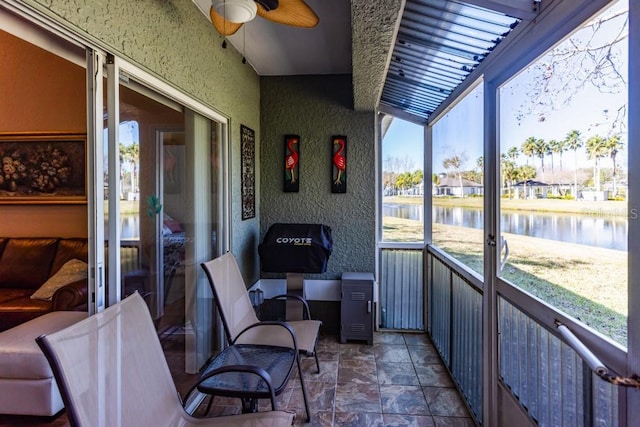 sunroom / solarium with a water view and ceiling fan