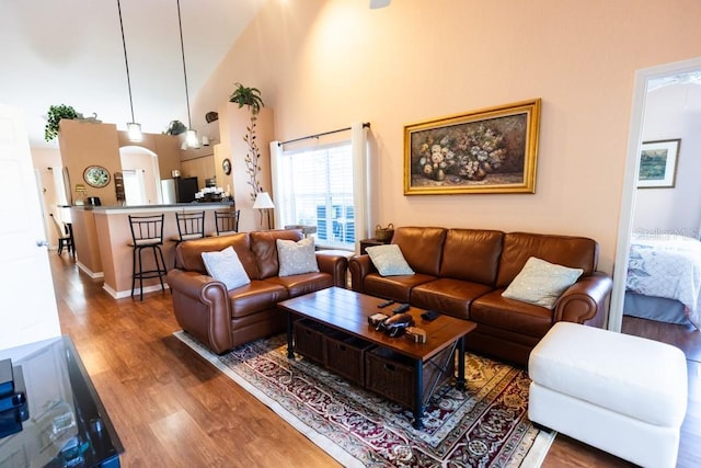 living room with hardwood / wood-style floors and a towering ceiling