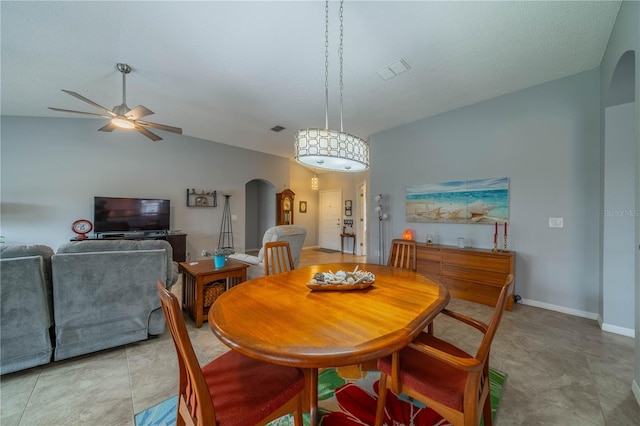 tiled dining space featuring lofted ceiling and ceiling fan