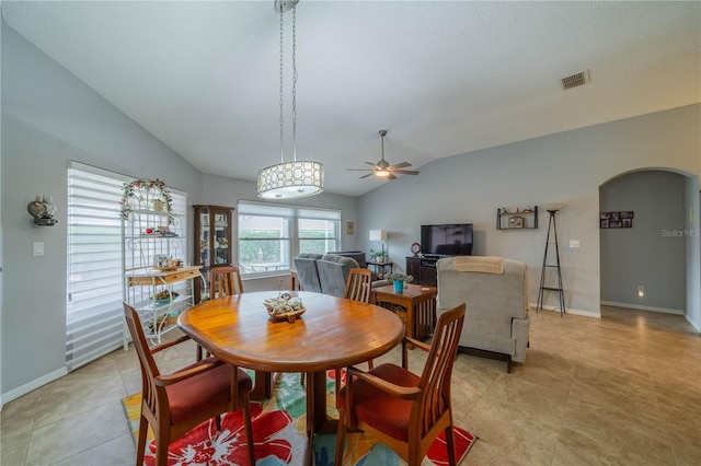 tiled dining room with ceiling fan and lofted ceiling