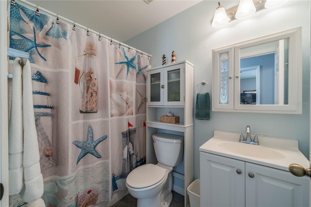 bathroom featuring vanity, toilet, and walk in shower