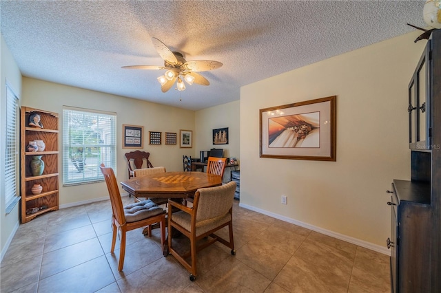 tiled dining room with ceiling fan and a textured ceiling