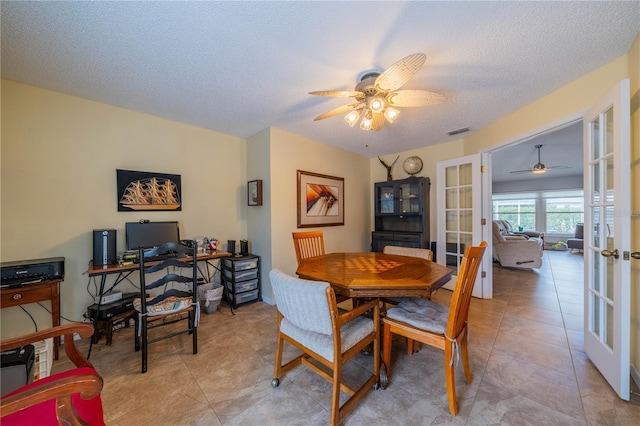 dining area with ceiling fan, french doors, a textured ceiling, and light tile patterned flooring