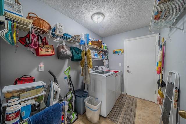 washroom with separate washer and dryer, light tile patterned floors, and a textured ceiling