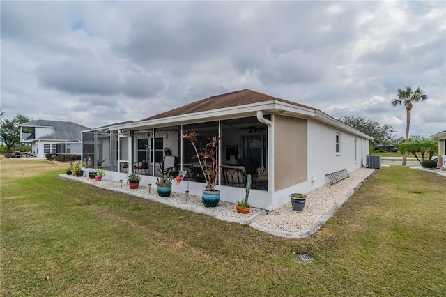 rear view of property with a sunroom, a yard, and cooling unit