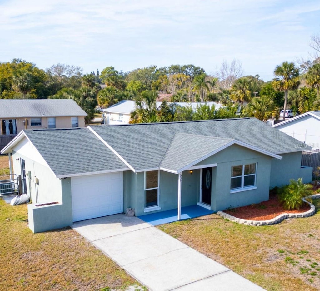 view of front of property with central AC unit, a garage, and a front yard