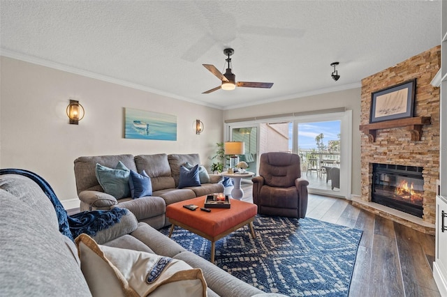 living room with crown molding, wood-type flooring, a textured ceiling, ceiling fan, and a fireplace