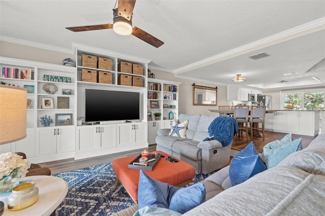 living room featuring crown molding, dark wood-type flooring, and ceiling fan