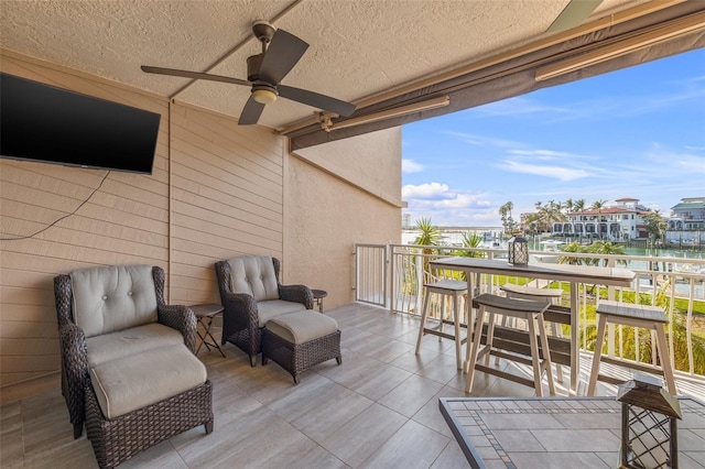 exterior space featuring a water view, an outdoor hangout area, and ceiling fan