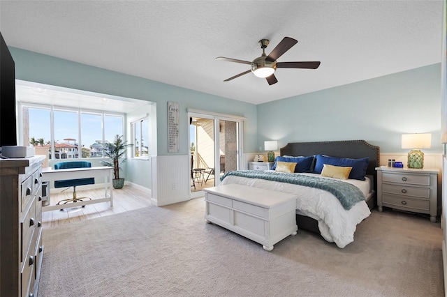 carpeted bedroom featuring ceiling fan, access to outside, and a textured ceiling