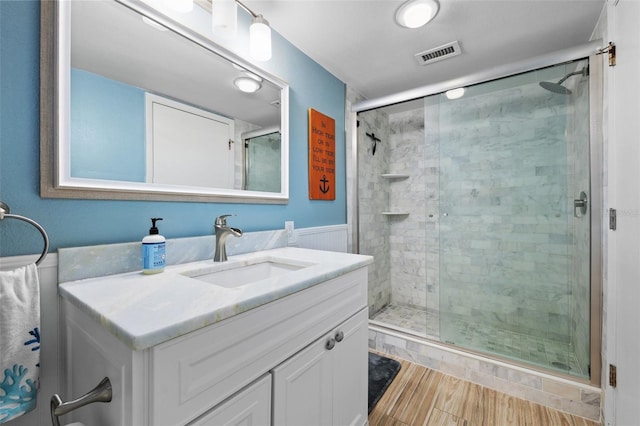 bathroom with vanity, an enclosed shower, and hardwood / wood-style floors