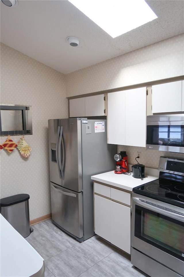 kitchen with white cabinetry, decorative backsplash, and stainless steel appliances