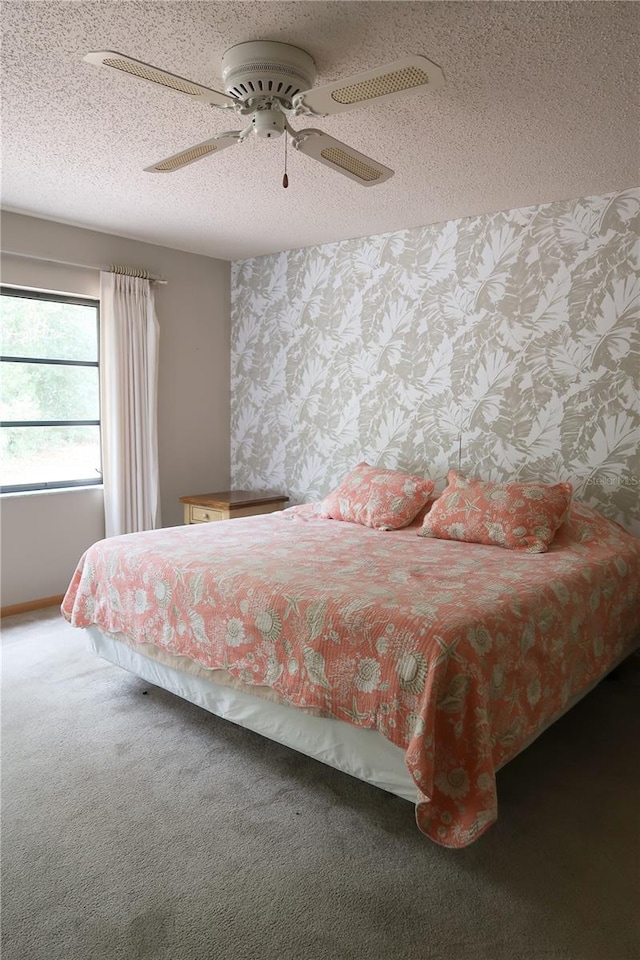 carpeted bedroom with a textured ceiling and ceiling fan