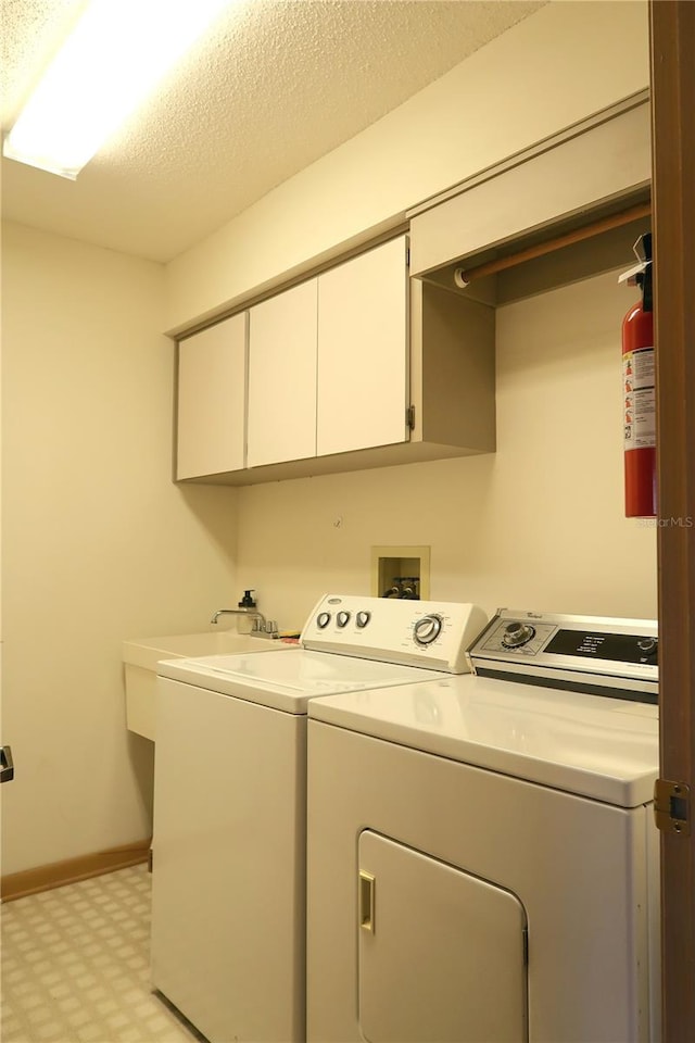 washroom featuring cabinets, independent washer and dryer, sink, and a textured ceiling