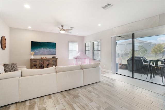 living room featuring light hardwood / wood-style floors and ceiling fan