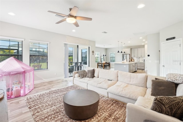 living room featuring ceiling fan and light wood-type flooring