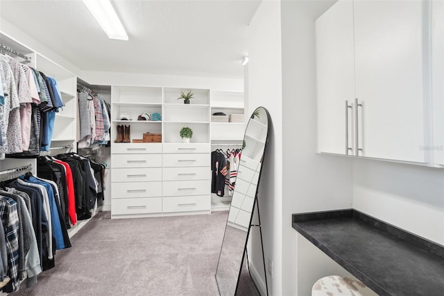 walk in closet featuring light colored carpet