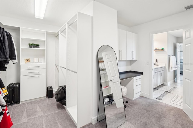 walk in closet featuring light carpet