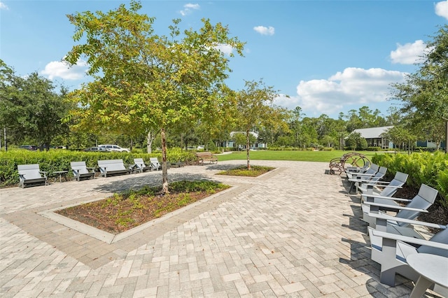 view of home's community with a patio area and a lawn