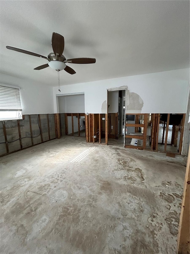 interior space featuring concrete flooring and a ceiling fan